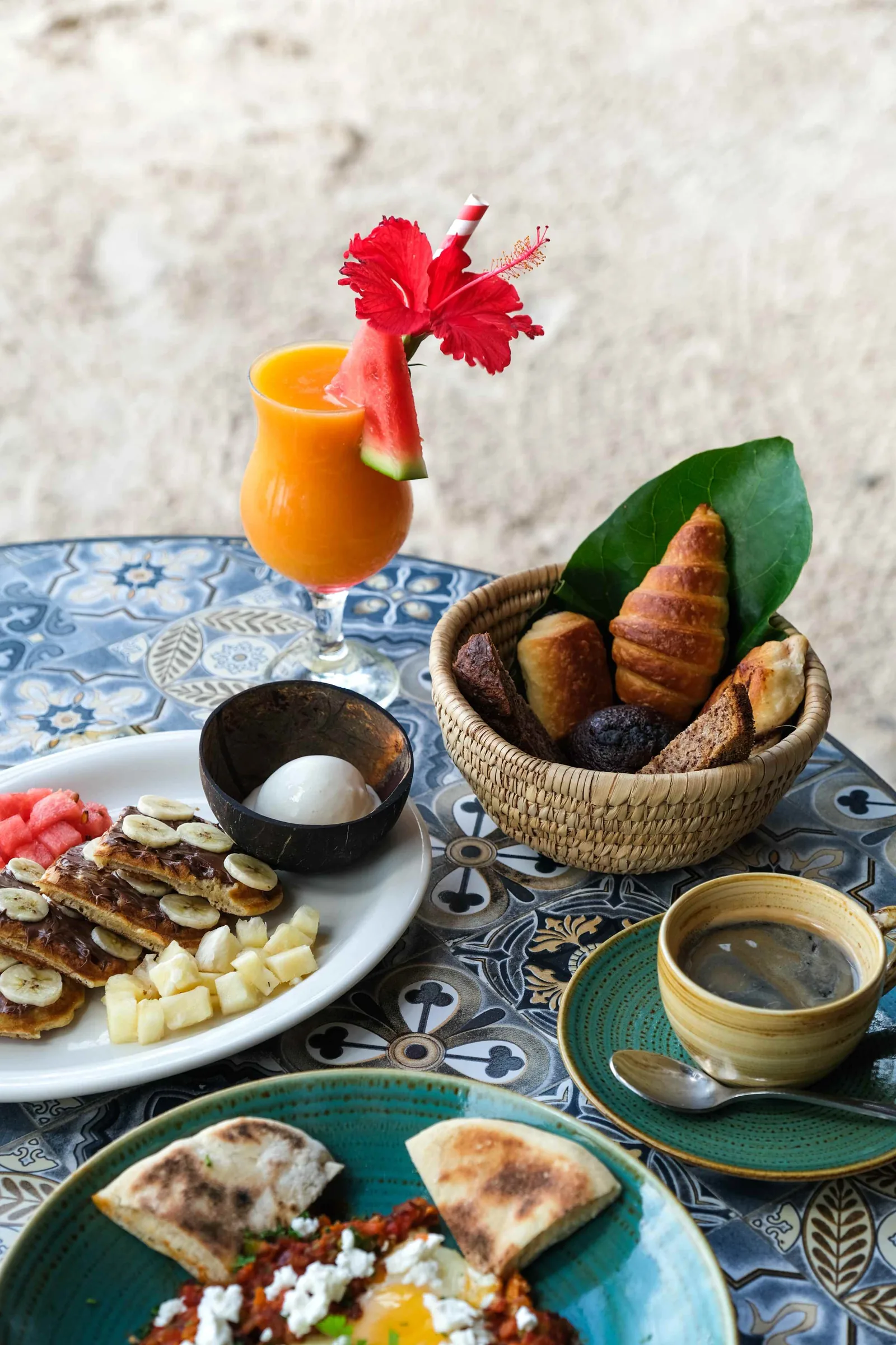 Breakfast with fruit, bread and juice among palm trees